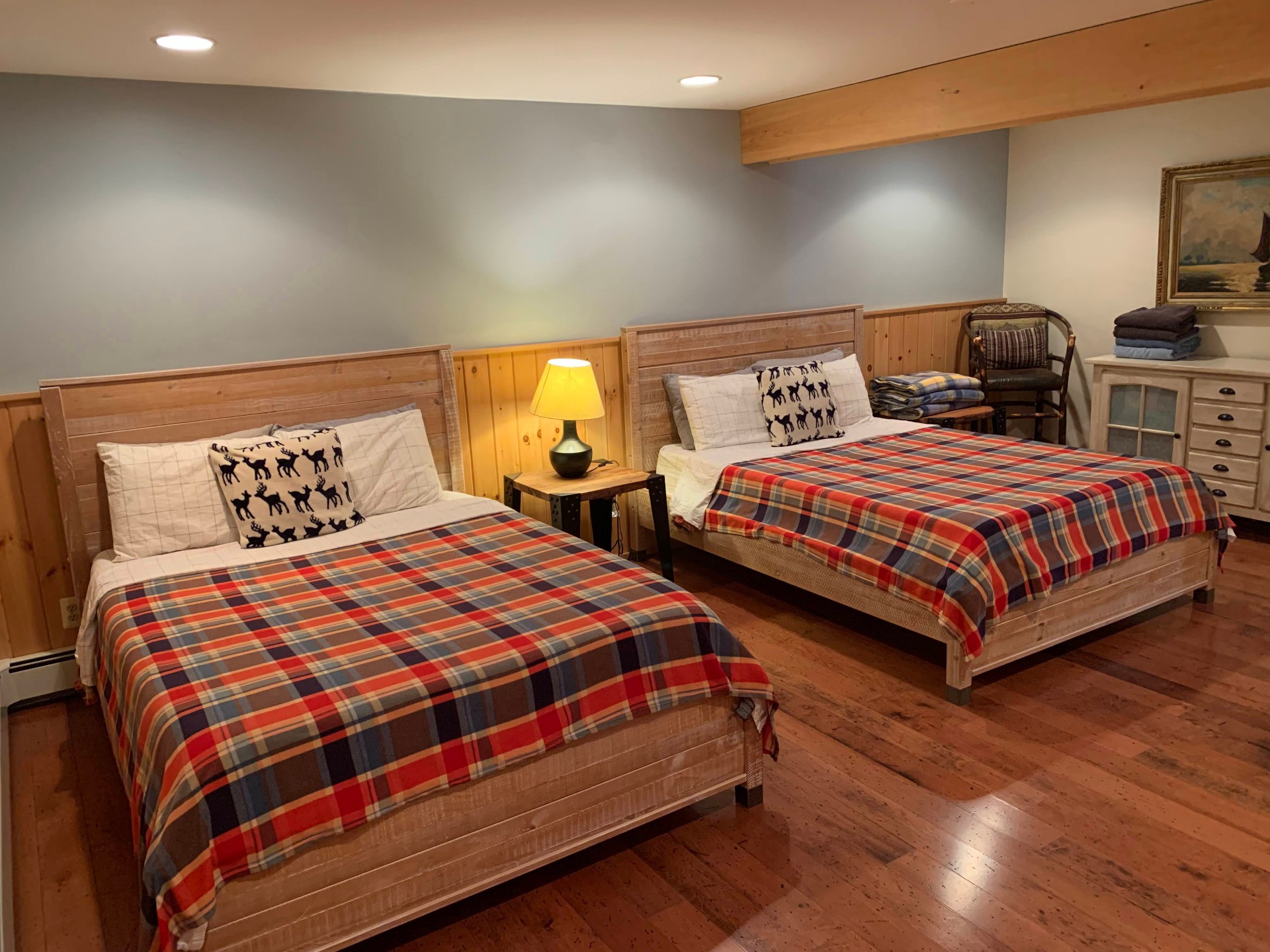Two queen beds in the downstairs den with plaid quilts